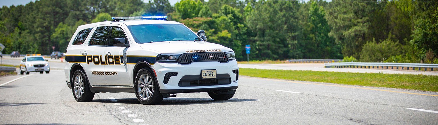 A Henrico County Police Dodge Durango stopped in the middle of a road with it's lights on.