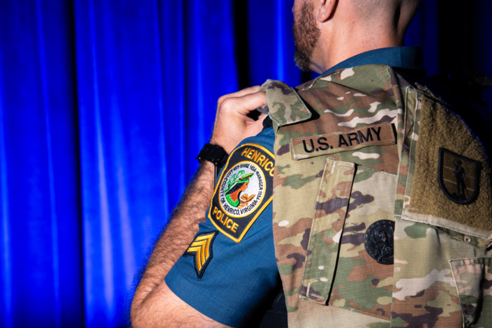 Henrico Police Officer with a U.S. Military Uniform draped over his shoulder near the Henrico Police patch.